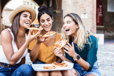 Pizza yiyip eğlenen üç genç kadın İtalya 'da yaz tatilinde birlikte eğleniyorlar. İnsanlar, kadın arkadaşlığı ve tatil kavramı.
