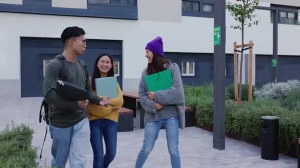 快乐的年轻的亚洲同学在课外互相聊天 三个中国高中生在放学后穿过校园 — 图库视频影像