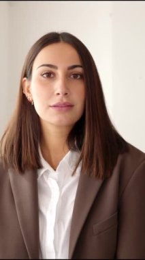 Ofiste kameraya bakan gülümseyen iş kadını. Kollarını kavuşturan genç iş kadınının kendinden emin portresi. Takım çalışması konsepti