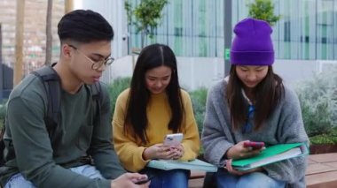 Bir grup Asyalı, akıllı telefon uygulamasında sosyal medya içeriğini izleyerek eğleniyor. Üç bin yıllık Çinli en iyi arkadaşlar cep telefonlarını açık havada tutuyorlar.. 