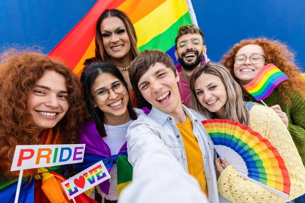 stock image Diverse LGTBQ young people with rainbow flags celebrating gay pride parade festival. Cheerful gay and lesbian community friends demonstrating for LGTB equal rights. Transgenders and homosexual people.