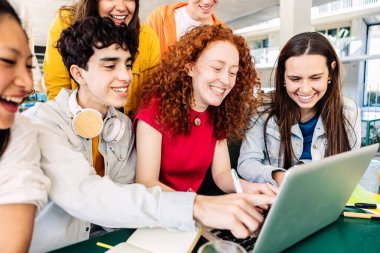 Üniversite kampüsünde birlikte okuyan bir grup genç öğrenci. Lise çağındaki genç sınıf arkadaşım kafeterya masasında dizüstü bilgisayarla çalışıyor. Eğitim kavramı.