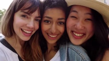 Üç farklı kadından oluşan genç bir grup dışarıda yan yana durarak gülümsüyor. Bin yıllık kadın arkadaşlarının neşeli bir portresi. Birbirlerine sevgi ve birlik göstererek kameraya bakıyorlar..