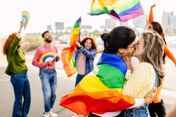 Lezbiyen çift LGBTQ geçit töreninde öpüşüyor. Birbirine aşık iki genç kız arkadaş. Eşcinsel ve lezbiyen topluluğunun çeşitli insanları lgbt onur gününü kutluyorlar.