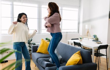 Ev partisinde kanepede dans eden iki mutlu kadın arkadaş. Kadın arkadaşlığı kavramı