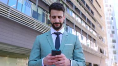 Genç yakışıklı iş adamı cep telefonu uygulaması hakkında bilgi arıyor. İş adamları ve teknoloji yaşam tarzı konsepti