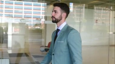 Başarılı bir iş adamı bina binasının önünde yürüyor. İş insanları kavramı.