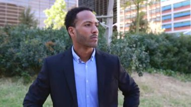 Düşünceli profesyonel iş adamı şehirdeki modern inşaat ofisinde oturuyor. Dışarıda bekleyen Afrikalı Amerikalı genç bir müdürün portresi..
