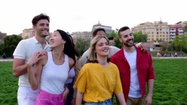 Bir grup genç arkadaş dışarıda eğleniyor. Milenyum gençleri şehir parkında eğleniyor. Arkadaşlık ve toplum kavramı.