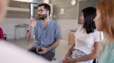 Erkek öğretmen, lisede çok ırklı genç öğrencilerle tartışma grubunu yönetiyor. Takım çalışması ve akademik tartışma konsepti