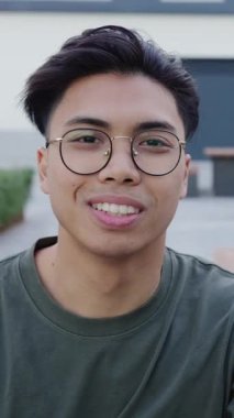 Kampüs kolejinde kameraya gülümseyen genç Asyalı adamın portresi. Filipinliler ve olumlu duygu kavramı. 