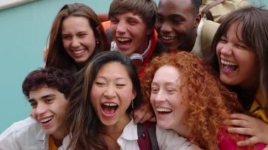 Erasmus öğrencilerinden oluşan mutlu bir grup açık havada birlikte gülüyor. Farklı kültürlerden milenyum insanları üniversite kampüsünde birlikte vakit geçiriyorlar. Gençlik toplumu ve arkadaşlık kavramı.