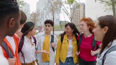 Üniversite kampüsünün dışında bir grup mutlu genç arkadaş konuşuyor. Neşeli milenyum öğrencileri dışarıda birlikte gülüp eğleniyorlar. Gençlik toplumu ve arkadaşlık kavramı.