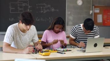 Bilgisayar eğitimi uygulaması kullanılarak çeşitli lise öğrencileri bilim robotik dersinde elektronik proje üzerinde çalışıyor. Sınıf arkadaşları sınıfta elektronik devreler yapmayı öğreniyor..