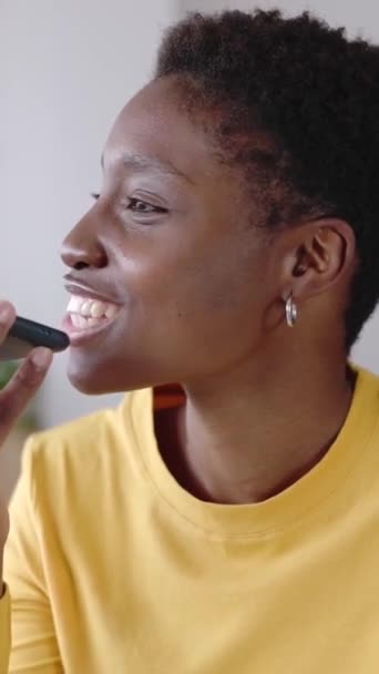若いアフリカの女性は 自宅からノートパソコンで作業しながら 友人に音声音声メッセージを録音するために携帯電話アプリを使用しています テクノロジーと若者文化の概念 縦型スクリーン電話ビデオ — ストック動画