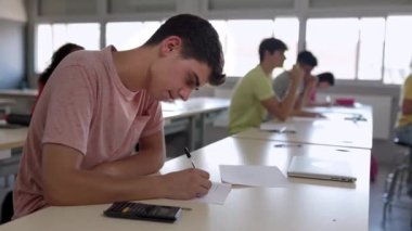 Bir grup lise öğrencisi sınıfta sınav yapıyor. Eğitim kavramı.