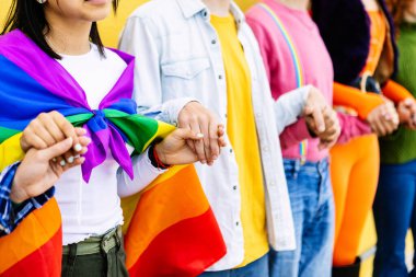 LGBT topluluğundan genç bir grup dışarıda el ele tutuşmuş destek, eşitlik, dahil etme ve birlik gösteriyorlar. Genç aktivist gösterici şehir sokaklarında gay onur günü festivalini kutluyor.