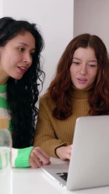 İki genç kadının iyi haberleri okuduktan ya da sınav sonuçlarını dizüstü bilgisayardan kontrol ettikten sonra birlikte kutladıkları dikey video. Genç kızlar e-postayla beklenmedik bir mesaj alıyorlar. Başarı konsepti.