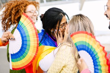 Lezbiyen çift, eşcinsel onur festivali kutlaması sırasında öpüşüyor. LGBTQ topluluk kavramı.
