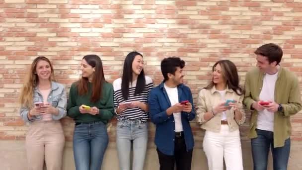 Szczęśliwa Grupa Młodych Ludzi Korzystających Telefonu Komórkowego Pochylających Się Razem — Wideo stockowe
