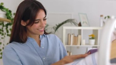 Genç serbest çalışan kadın galeride giysileri kontrol ediyor. Stüdyoda çalışan küçük bir kadın işyeri sahibi. Girişimci ve serbest çalışan insanlar kavramı.