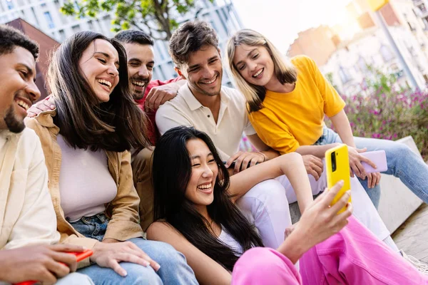 若い世代の世代が携帯電話を一緒に外で楽しんでいます スマートフォンアプリでソーシャルメディアコンテンツを楽しむ学生ゾーマーの陽気なコミュニティ — ストック写真