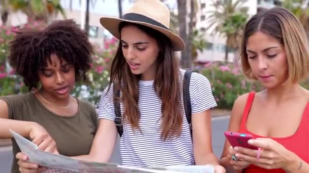 市内の夏休み観光を楽しむマップを探している3人の多人種女性の友人 旅行と休日のコンセプト — ストック動画