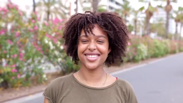 Portret Radosnej Afrykańskiej Kobiety Kręconymi Włosami Uśmiechniętej Kamery Stojącej Zewnątrz — Wideo stockowe