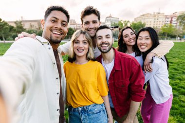 Üniversiteden bir grup genç arkadaş dışarıda selfie çekiyorlar. Kampüs üniversitesinde birlikte gülüp eğlenen mutlu gençlik topluluğu..