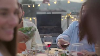 Bir grup çok ırklı arkadaş evdeki terasta barbekü partisinin tadını çıkarıyor.. 