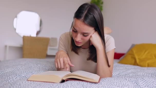 Junge Schöne Frau Liest Ein Buch Das Auf Dem Bett — Stockvideo