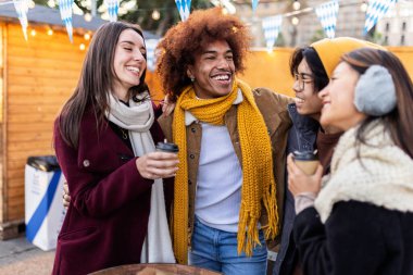 Çok ırklı bir grup arkadaş Noel pazarında sıcak içecekler içiyor. Milenyum öğrencileri her gün kışın eğleniyor. Arkadaşlık kavramı.