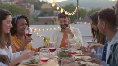 Genç bir grup insan akşam yemeğinin tadını çatıdaki evde çıkarıyor. Milenyum arkadaşlarıyla teras masasında bir araya gelip gece barbekü partisini kutluyorlar..