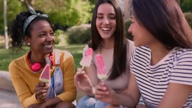 Neşeli, çoklu etnik çeşitlilikte bir grup kadın arkadaş sohbet ediyor ve birlikte eğleniyorlar. Yaz tatilinde eğlenirken karpuzlu dondurma yiyen çeşitli turist kadınlar. Mutluluk ve arkadaşlık kavramı