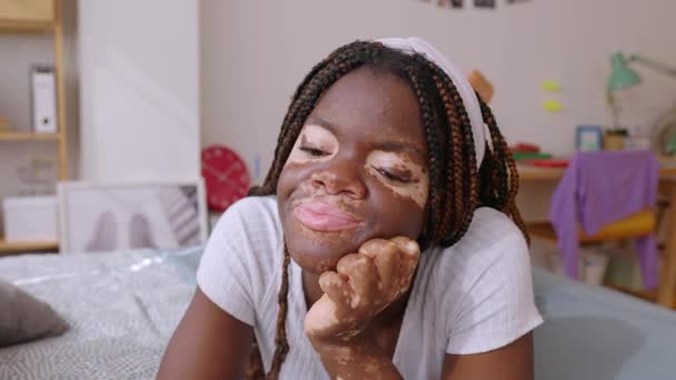 ベッドに横たわる夢を見るアフリカの若い笑顔の女性 広大なミレニアル世代の女性が部屋でリラックス — ストック動画