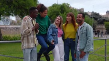 Bir grup genç insan şehir caddesinde takılıyor. Dışarıda dikilen, konuşan, sohbet eden beş çok ırklı arkadaş. Yüksek kalite 4k görüntü