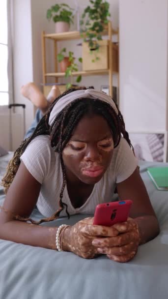Vertikalt Skott Glad Ung Kvinna Med Vitiligo Med Smartphone Sängen — Stockvideo
