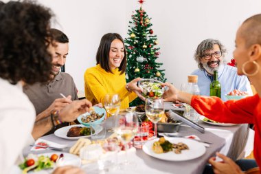Mutlu çoklu jenerasyon aileleri evde Noel yemeğinin tadını çıkarıyor. Geniş bir grup insan birlikte eğleniyor. Xmas 'ın yemek masasının etrafında buluşmasını kutluyorlar..