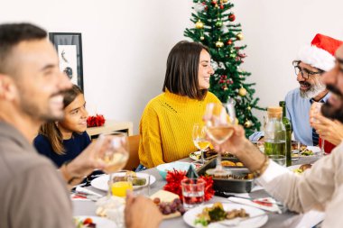 Mutlu çoklu jenerasyon aileleri, akşam yemeğinin tadını çıkarıyorlar evde masada birlikte oturuyorlar. Farklı insanlar Noel 'i kutluyor. Tatil ve kutlama konsepti.