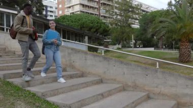 İki farklı üniversite öğrencisi dersten sonra binadan çıkıyorlar. Çeşitlilik ve eğitim kavramı.