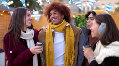 Çok ırklı bir grup arkadaş Noel pazarında sıcak içecekler içiyor. Milenyum öğrencileri her gün kışın eğleniyor. Arkadaşlık kavramı.