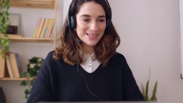 在办公室的笔记本电脑上工作的年轻成年女商人 带耳机的职业女性通过在线视频通话与伴侣交谈 呼叫中心服务 业务和人员概念 — 图库视频影像