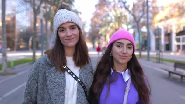 Şehir Arka Planında Yürürken Kameraya Gülümseyen Kışlık Elbiseli Iki Kadının — Stok video