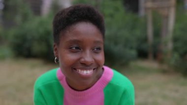 Şehir sokağında oturan genç siyahi kadın portresi. Pozitif Afrikalı kadın dışarıda birini bekliyor..