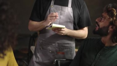 Restorandaki bir grup arkadaştan sipariş alan genç garsonların elleri. Küçük işletme ve insan konsepti.