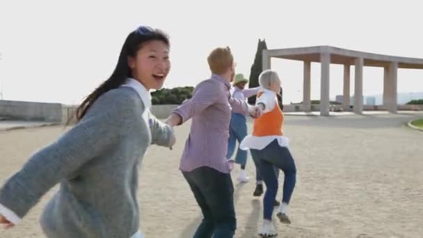 Νεανική Ομάδα Ανθρώπων Που Διασκεδάζουν Τρέχουν Μαζί Κρατώντας Χέρια Έξω — Αρχείο Βίντεο