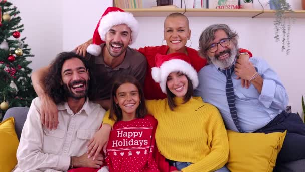 圣诞前夕坐在圣诞树旁沙发上的三代家庭微笑的画像 — 图库视频影像