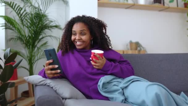 Giovane Donna Afroamericana Rilassante Sul Divano Utilizzando Telefono Cellulare Mattino — Video Stock