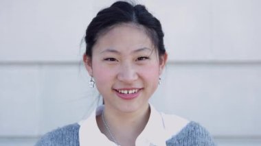 Genç Asyalı mutlu kadının dış görünüşü kameraya gülümsüyor. Neşeli insanlar konsepti.