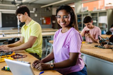 Lisede oturan Afrikalı Amerikalı genç kız kameraya gülümsüyor. Eğitim yaşam tarzı kavramı.
